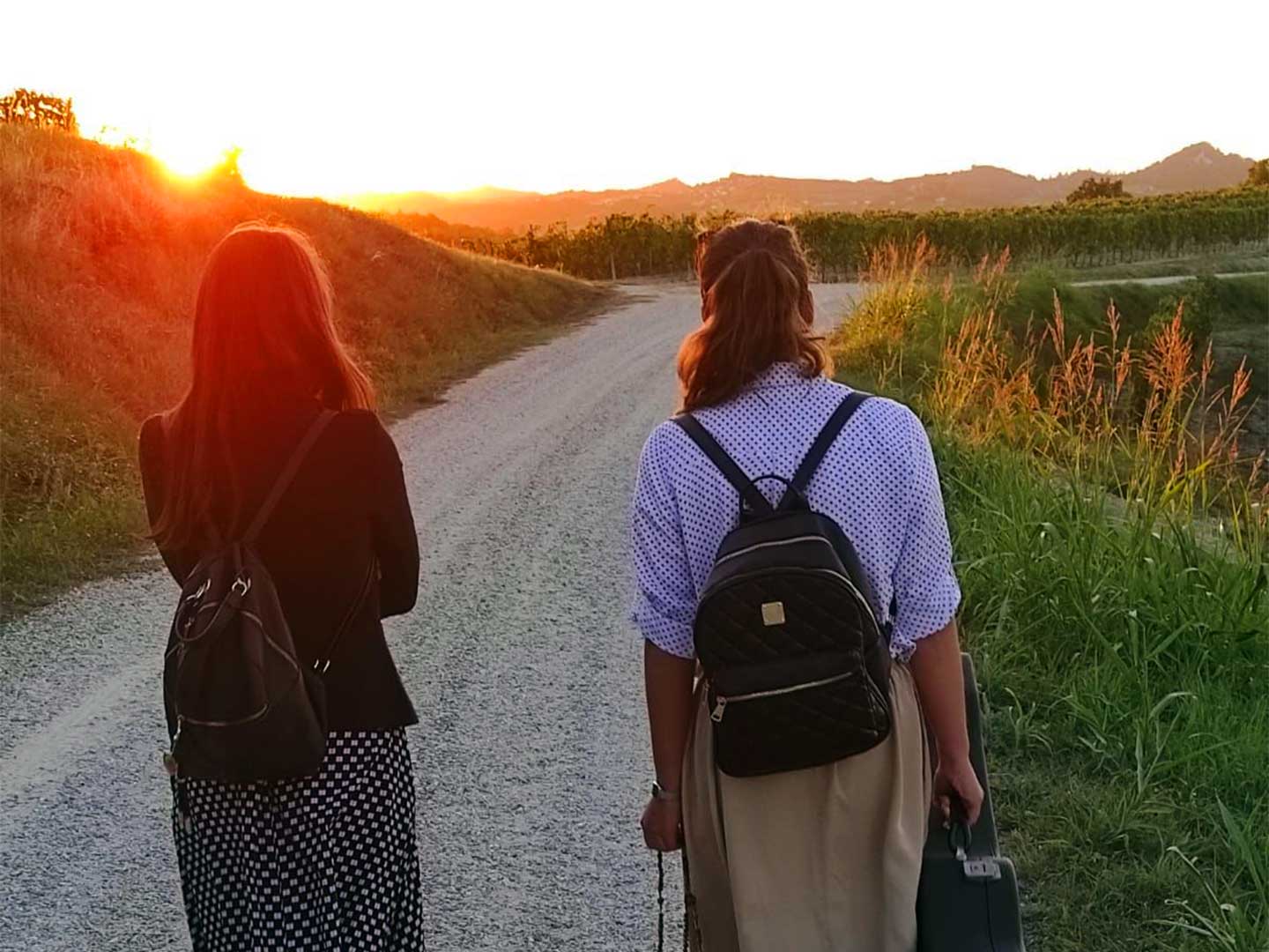 Vista di spalle sorelline mentre passeggiano al tramonto